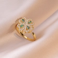 Elegant gold clover ring with green gems and white zircon on pink silk background - Emerald Ring / Gold