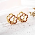 Macro detail of gold flower earrings with red zircon stones on a white background - Ear Buckle / Gold Red Flower