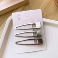 Close-up of three silver Y2K metal hair clips on a pink card with a smooth finish - Hollow Square Water Drop Style / Set of 3