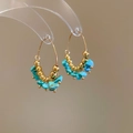 Dettaglio macro di perline dorate bohémien e pietre turchesi su orecchini a cerchio - Oro-Blu