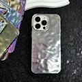 Macro detail of silver water ripple texture on iPhone case with metal camera ring - Starlight Silver / iPhone 12