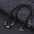 Detail of beaded necklace featuring black agate and tiger eye stones with metal clasp - Tiger's Eye