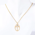 Textured gold zodiac pendant necklace with blue gemstone displayed on a mannequin - Aries