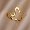 Macro detail of gold wavy open ring with high-polished finish on silk fabric background - Gold Wave Geometric