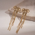 Makro-Detail von 18K Gold Schleifenohrringen mit Zirkonia und langen Kettenquasten - Gold