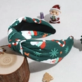 Detailed close-up of green knotted headband with Santa and candy cane festive prints - Green Santa