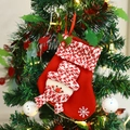 Christmas stocking with 3D snowman pattern hanging on a decorated tree with warm lights - Snowman