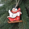 Christmas snowman in a red sleigh hanging ornament on a green pine tree branch - Red Sleigh Snowman