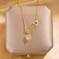 Goldene Sicherheitsnadel-Halskette mit rosa Herzanhänger und Kristallen auf Schmuckbox - T50 Gold
