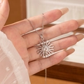 Fashionable silver sun pendant necklace in titanium steel held by hand over a jewelry box - Steel Color Sun Face Necklace