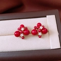 Dettaglio macro di orecchini con perle rosse placcati oro 18K e accenti in zircone - Orecchini a Lobo con Grappolo di Perle Rosse / Stile Fuochi d'Artificio Rossi (Perno in Argento-Oro-Rosso-Fuochi d'Artificio-Placcato Oro 18K)
