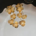 Boucles d'oreilles fleurs dorées à franges avec strass brillants sur plateau blanc - No.14 Clous d'Oreilles à Pampilles Fleur Rayée Tige Argent