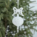 Sparkling white Christmas drop ornament with bow tie hanging on a festive tree branch - White Irregular Shape
