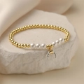 Detail of gold beaded pearl bracelet with a marble texture crescent moon pendant - White Shell Moon