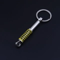 Detailed view of silver car shock absorber keychain with yellow spring and metal ring - Yellow Shock Absorber