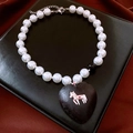 Detail shot of pearl necklace with large black heart stone pendant and silver horse icon - Necklace-Black-Silver