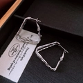 Detail view of silver geometric triangular earrings with twisted multi-layer design - Silver (925 Sterling Silver Earring Post)