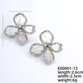 Elegant silver flower stud earrings with crystal petals and textured metal finish - Silver + White Zircon