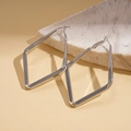 Macro view of geometric diamond shaped silver hoop earrings on a marble stone base - Large / Silver