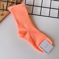 Detail of orange cotton socks with Empole paper tag on a clean white background - One Size / Fluorescent Orange