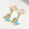 Detailed close-up of golden bear earrings with pink and blue stones on white background - Mouse