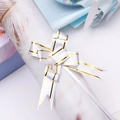 Macro detail of white gift pull bow ribbon with gold stripes for festive packaging - White Gold Edge