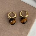 Goldene Creolen mit braunen Tigerauge-Perlen auf strukturiertem braunem Stoff - Goldring Einzelner Großer Tigerauge-Stil