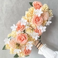 Handheld floral arrangement with pink coral roses and yellow carnations on gray wall - Yellow Pink 2
