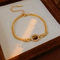 Detailansicht eines vergoldeten Armbands mit ovalem Tigerauge und Zirkonia-Besatz - Gold