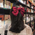 Close-up of a large wine red satin bow hair clip worn on the back of the head - Big Bow #Red