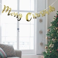 Golden Merry Christmas banner with metallic finish hanging in a festive holiday scene - Gold Card / Gold