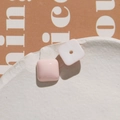Close-up of pink and white resin square charms on an artistic white ceramic plate - Pink Square