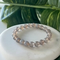 Translucent gray agate beaded bracelet displayed on a white marble stone platform - Grey Agate / 4mm