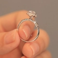 Silver flower ring with rose gold petals and moissanite stone held on a finger - Little Swan Ring Ljz-142 / Adjustable Open