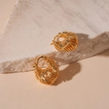 Dettaglio macro di orecchini a cerchio a U placcati oro con texture intrecciata su pietra - Clip per orecchio a forma di U a bobina / Oro