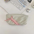 Astuccio in morbido tessuto verde chiaro con fiocco rosa in una scena di ufficio in casa - Grigio chiaro