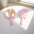 Close-up of pink rose-shaped handheld mirror showing relief flower design and reflective glass - Soft Pink