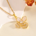 Elegant gold bow necklace with heart stones and shell inlays on a decorative stone base - Gold Double Shell Double Hollow Bowknot Necklace