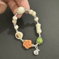 Detailaufnahme des chinesischen Armbands mit bunten Keramikperlen und Silberanhängern - 05 Knochen Geldbeutel