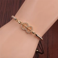 Detail of three-tone heart bracelet with zircons and adjustable black cord on wrist - Gold Heart Arrow with Tricolor Beads