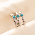 Dettaglio dell'anello a triplo strato in acciaio argento con pietre turchesi su tessuto - Triplo Strato con Perline / Argento Blu Scuro