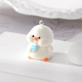 Gros plan d'un pendentif poussin blanc floqué avec bavoir bleu pour la création de bijoux - Canard Blanc