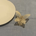 Detail of translucent cream butterfly hair claw clip with golden metal spring on fabric - Gradient Yellow