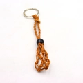 Detail of hand-woven orange cord mesh bag keychain with black bead and silver ring - Keychain / Coffee