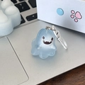 Close-up of a translucent light blue ghost keychain on a laptop with a white metal hook - Floating Ghost