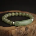 Elastic beaded bracelet with green jade stones and curved jade bar on wood texture - Green Aventurine