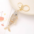 Detailed close-up of a golden fish keychain with sparkling crystal rhinestones and lobster clasp - Jointed Fish