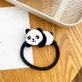 Elastic ponytail holder with cute black and white panda charm on wooden surface - Prone Panda Scrunchie