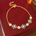 Dettaglio macro del bracciale vintage con perle catena dorata e petali in zircone - Oro-Blu