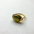 Close-up of an 18K gold plated ring featuring a large oval green gemstone and zircon - US 6 / Dark Green